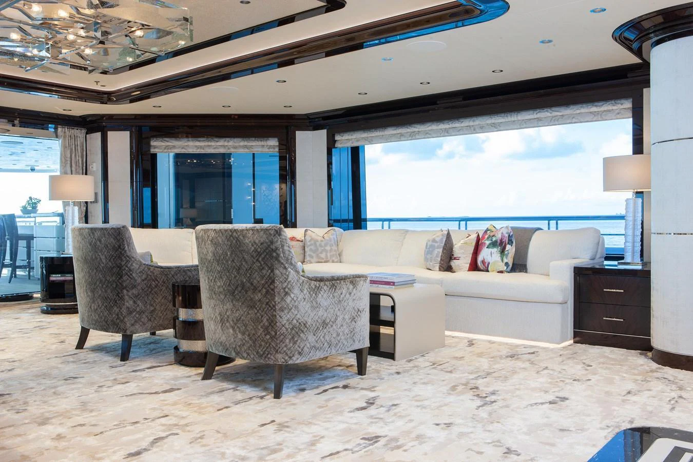 The salon features luxurious seating with expansive windows offering stunning ocean views. aboard BOARDWALK V Yacht for Sale