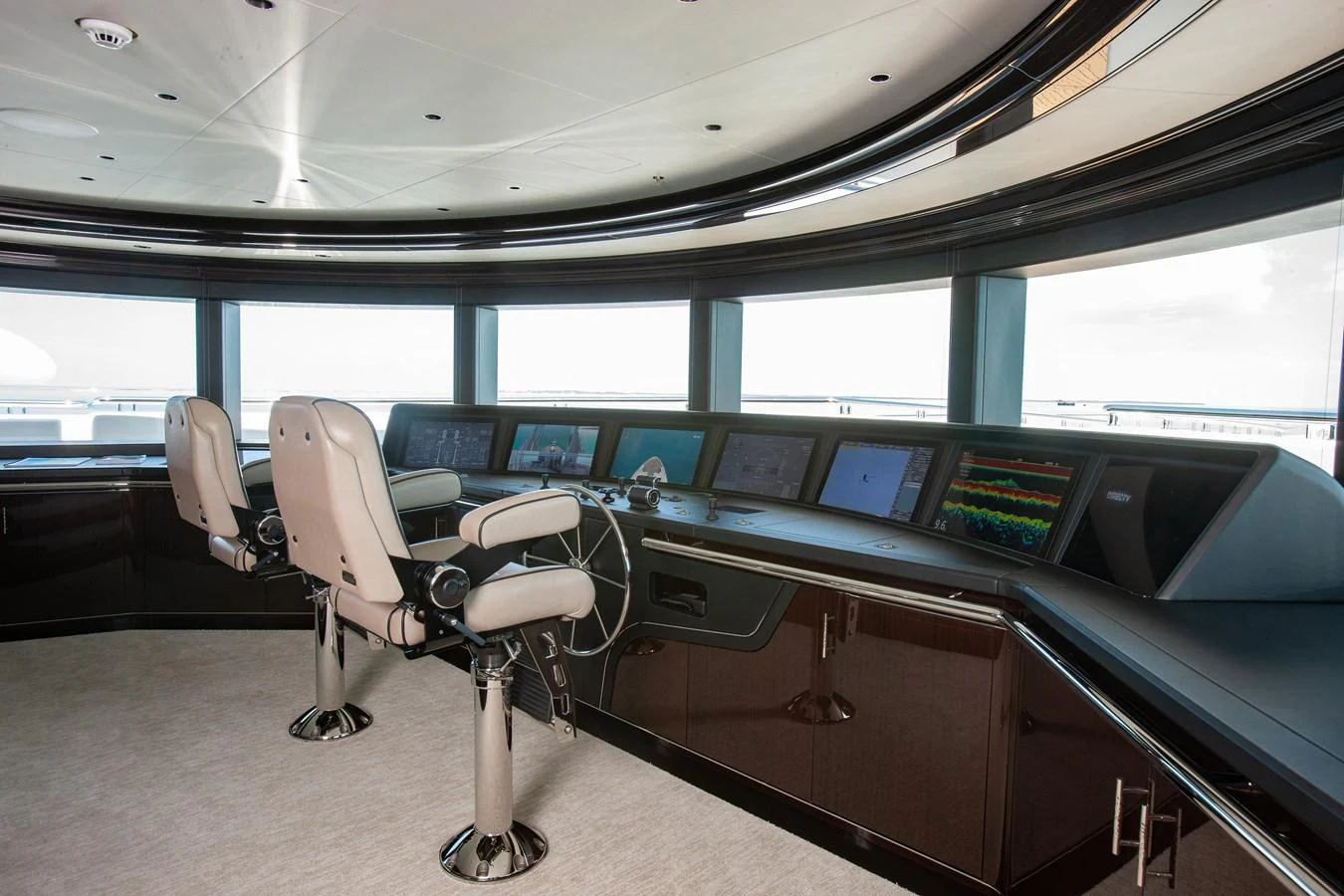 The helm station features advanced navigation equipment and luxurious seating, offering a commanding view for the captain. aboard BOARDWALK V Yacht for Sale