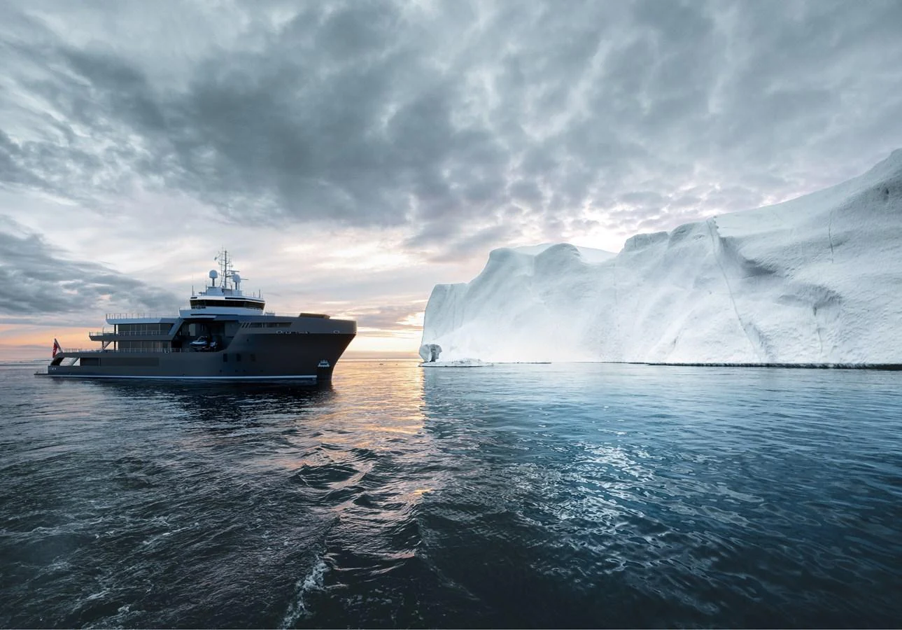 A sleek yacht cruises past a majestic iceberg under a dramatic sky. aboard PROJECT MASTER Yacht for Sale