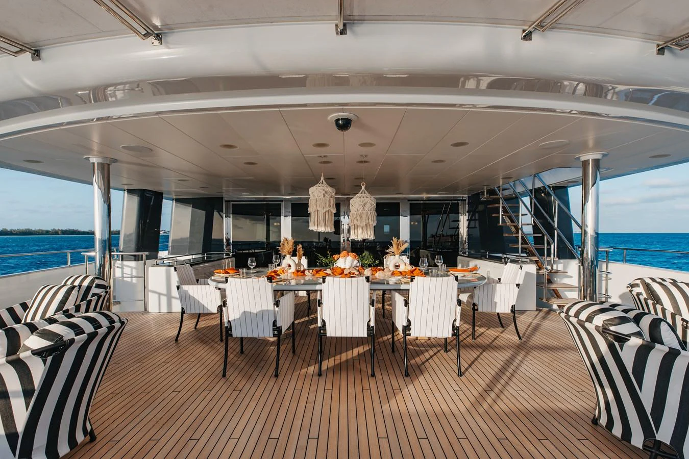 The aft deck features an elegant dining area with a large table and stylish seating, perfect for alfresco meals. aboard ETERNITY Yacht for Sale
