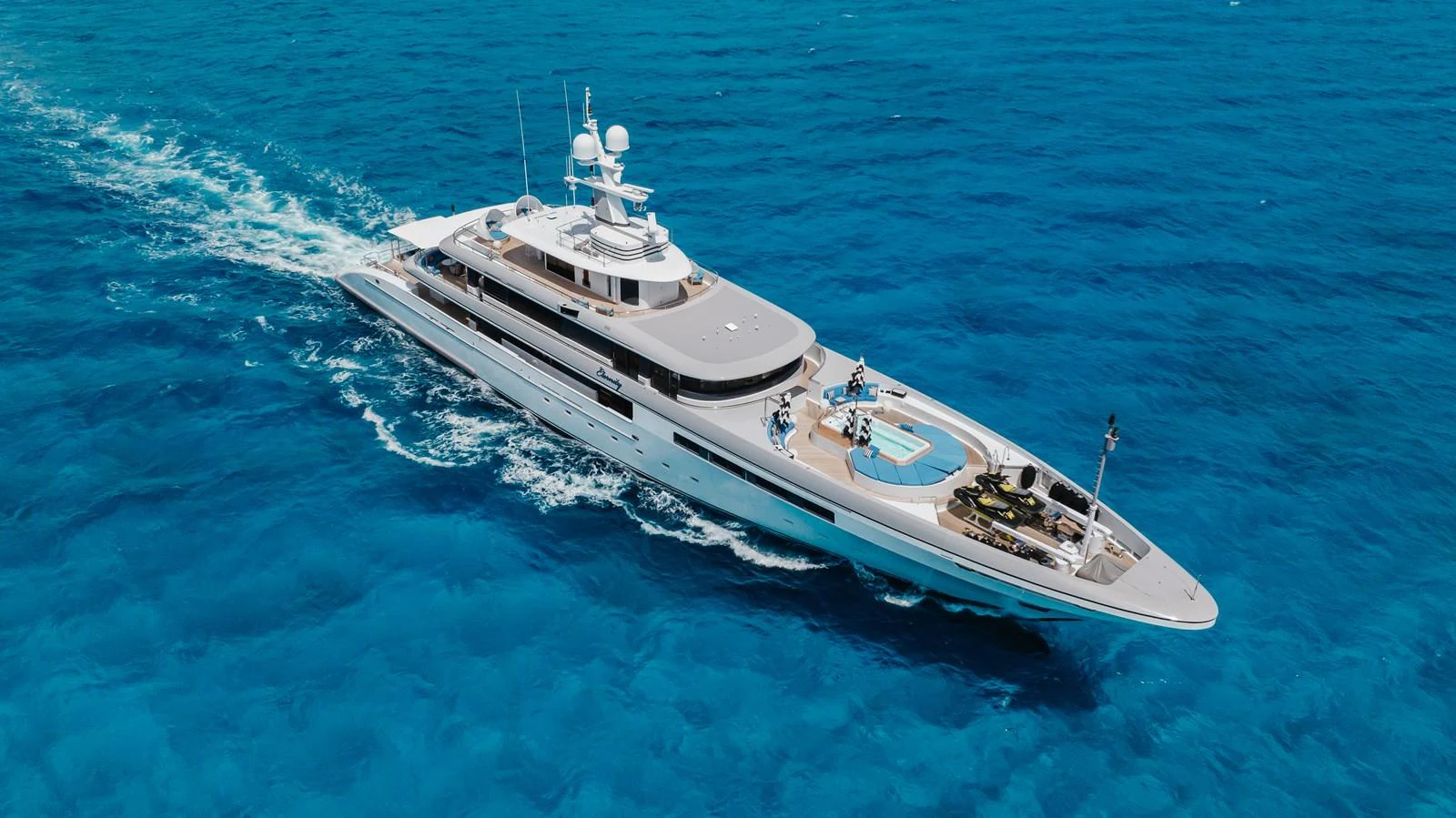 A sleek and modern yacht cruises through vibrant blue waters, showcasing its elegant design and spacious deck areas. aboard ETERNITY Yacht for Sale