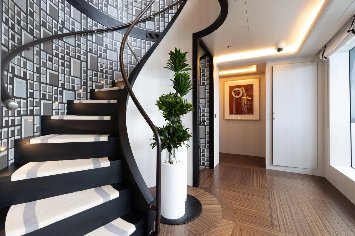 A stylish interior staircase with modern decor and a potted plant. aboard ETERNITY Yacht for Sale