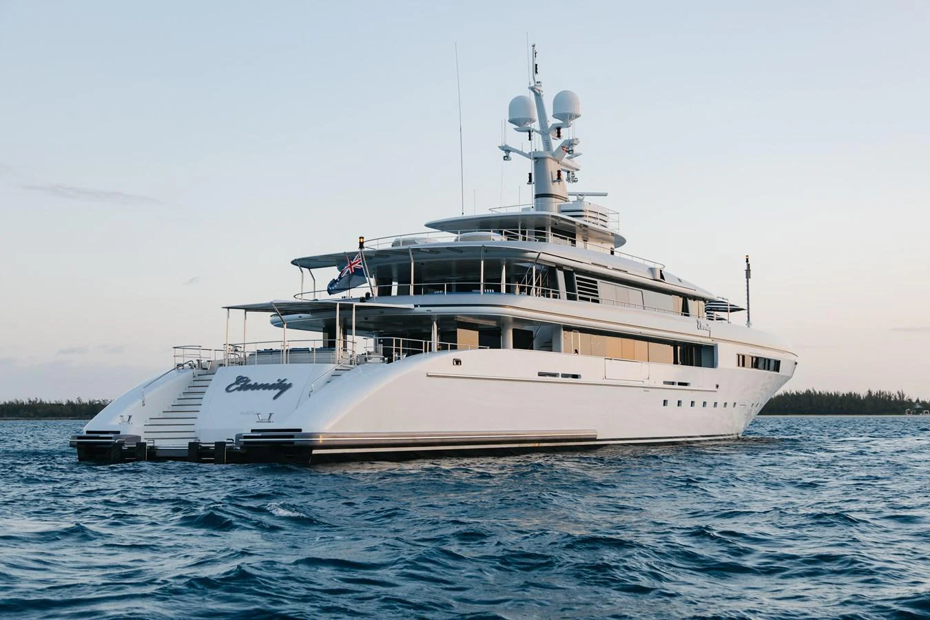 A sleek and modern yacht cruising on calm waters during a serene evening. aboard ETERNITY Yacht for Sale