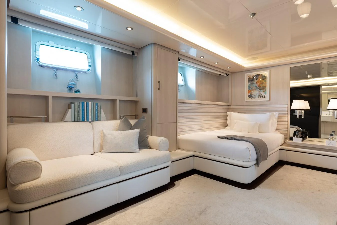 The stateroom features a luxurious bed, a comfortable sofa, and elegant decor with ample natural light. aboard ETERNITY Yacht for Sale