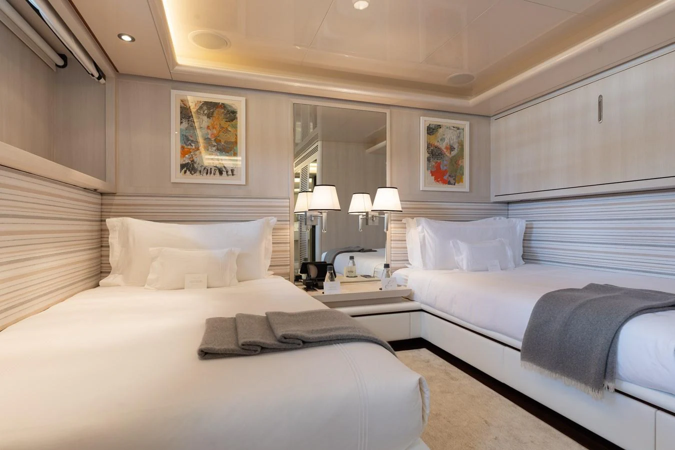 The guest stateroom features twin beds, elegant decor, and modern art pieces, creating a cozy and inviting atmosphere. aboard ETERNITY Yacht for Sale
