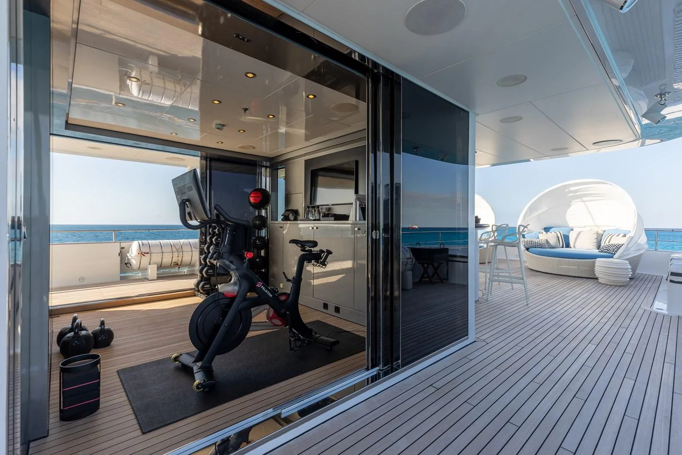 The yacht features a sleek, modern gym area with a view of the ocean. aboard ETERNITY Yacht for Sale