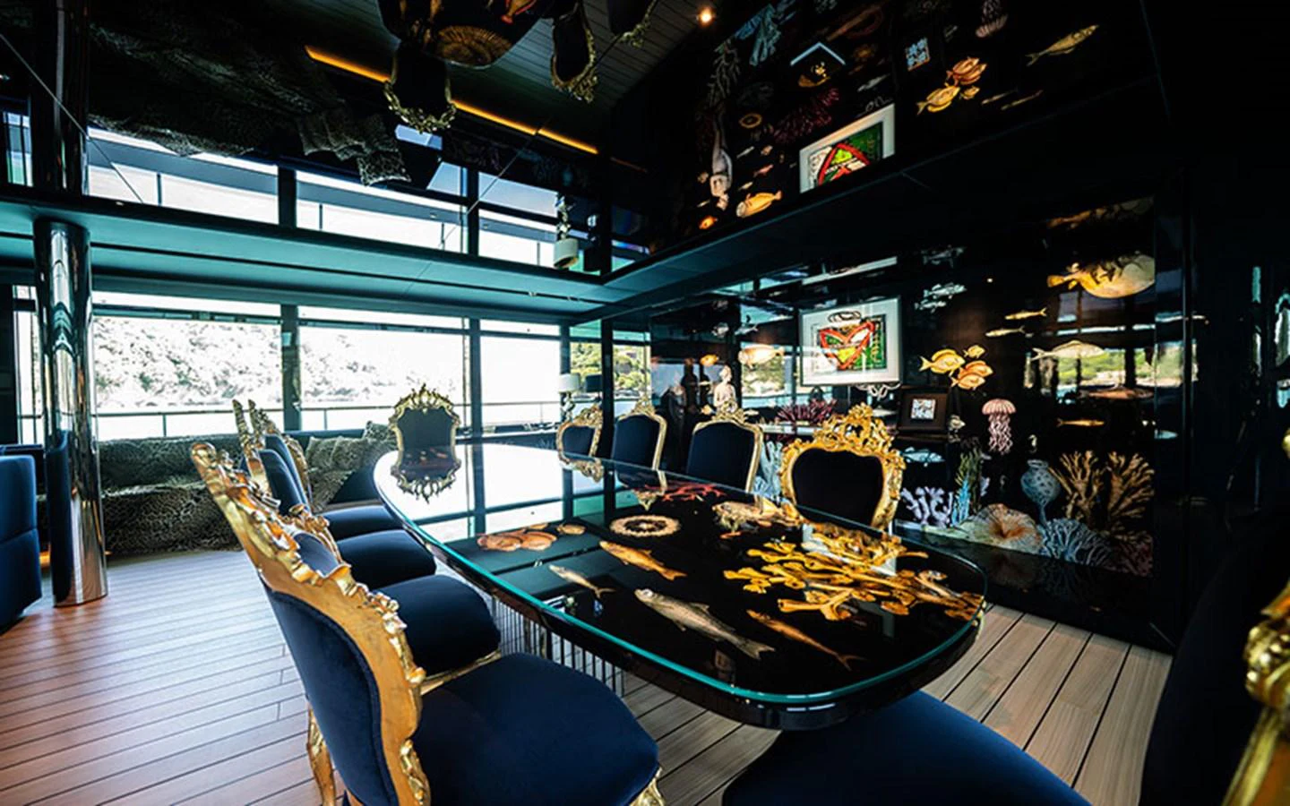 The yacht's dining area features an opulent table with intricate designs and luxurious seating, surrounded by large windows offering scenic views. aboard REGINA D'ITALIA Yacht for Sale