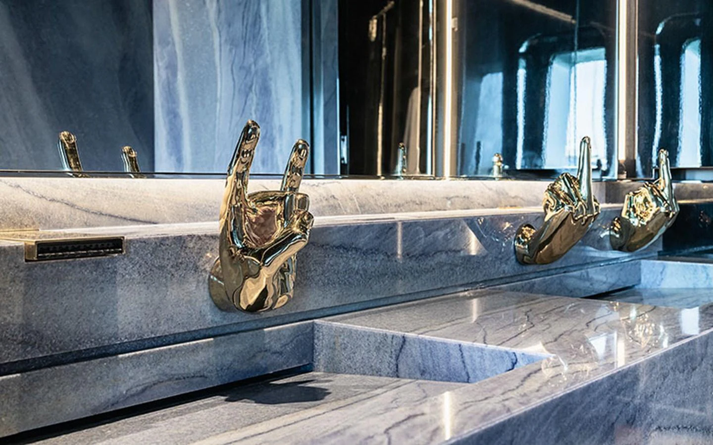 A luxurious bathroom detail featuring unique gold hand-shaped fixtures and elegant marble surfaces. aboard REGINA D'ITALIA Yacht for Sale