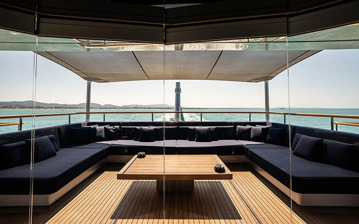 The aft deck features a spacious seating area with a large wooden table, perfect for relaxation and socializing while enjoying the ocean view. aboard REGINA D'ITALIA Yacht for Sale