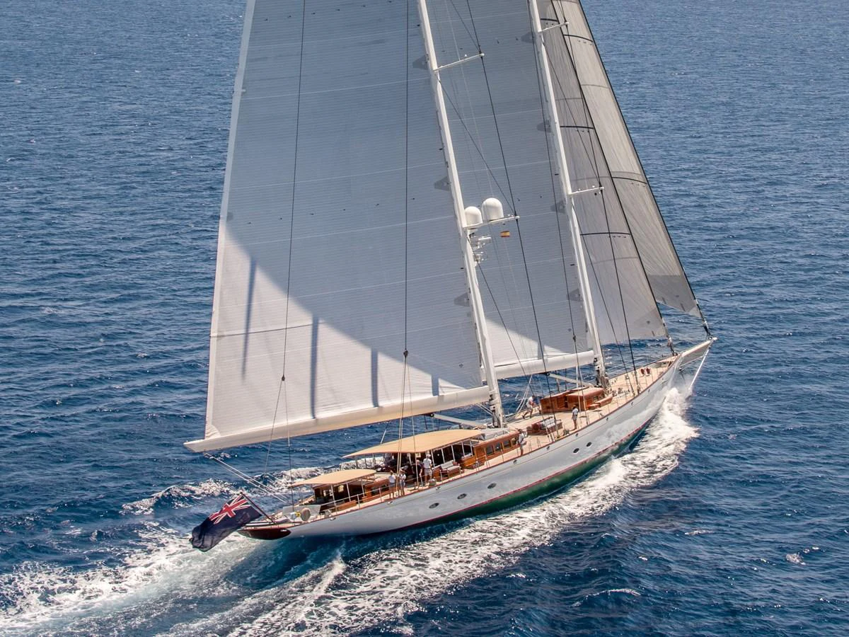 A stunning sailing yacht glides gracefully across the open sea under full sail. aboard ATHOS Yacht for Sale