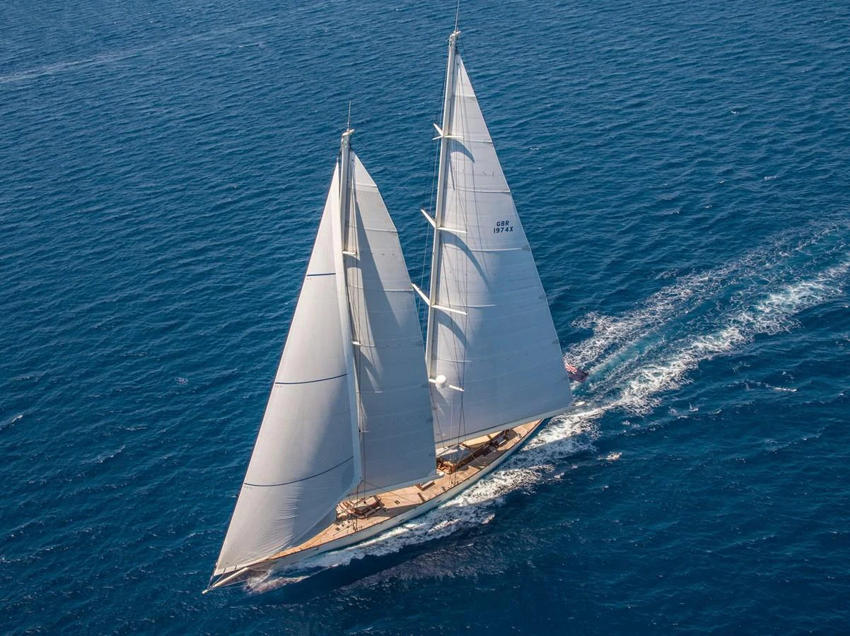 A majestic sailing yacht glides gracefully over the deep blue sea. aboard ATHOS Yacht for Sale