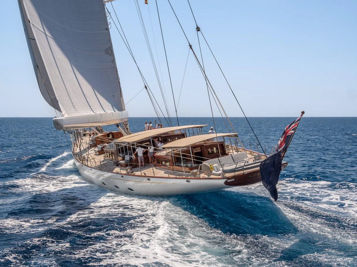 A classic sailing yacht gracefully cuts through the waves under full sail. aboard ATHOS Yacht for Sale