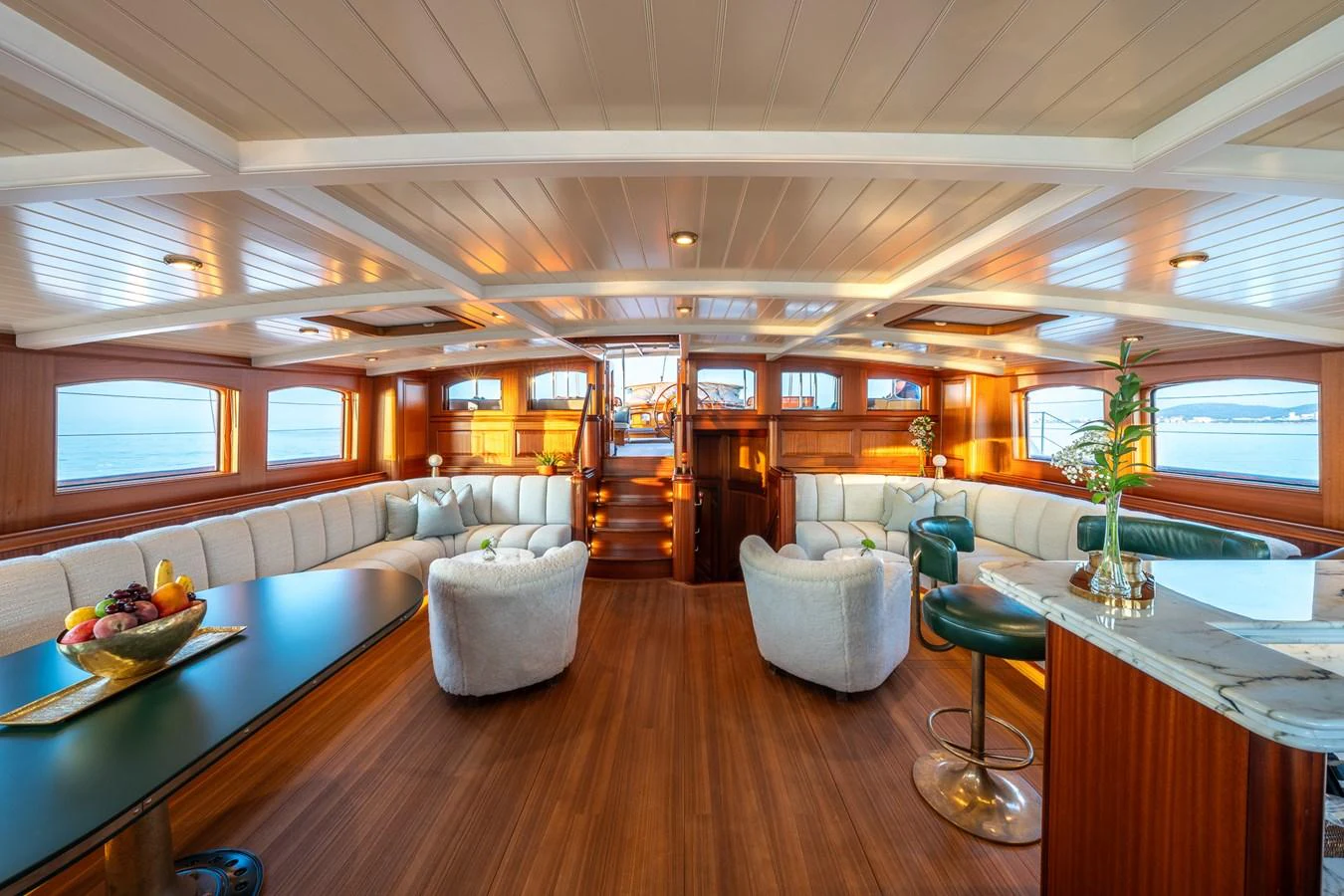 The salon features elegant wood finishes, plush seating, and panoramic windows for a luxurious and inviting atmosphere. aboard ATHOS Yacht for Sale