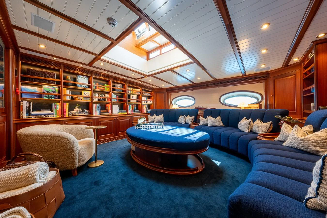 The salon features luxurious seating, a skylight, and elegant wood paneling. aboard ATHOS Yacht for Sale