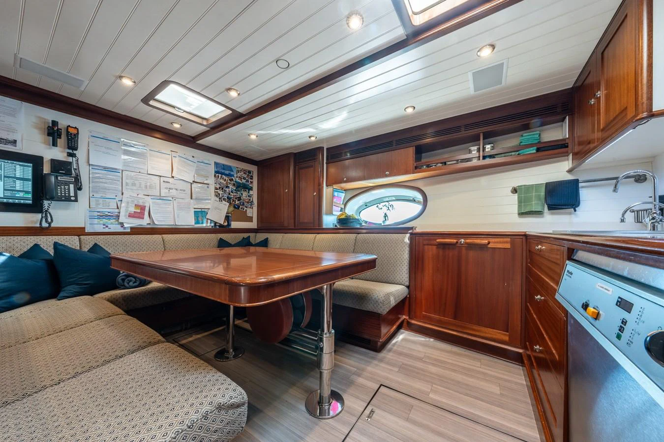 The galley features a cozy dining area with rich wood cabinetry and modern appliances. aboard ATHOS Yacht for Sale