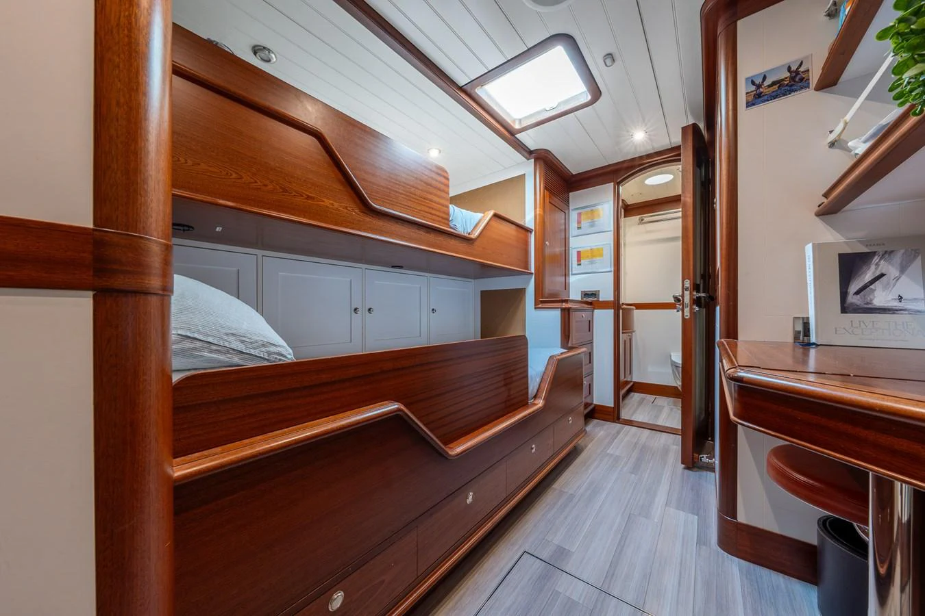 The cabin features cozy wooden bunk beds and a functional workspace, creating a warm and inviting atmosphere. aboard ATHOS Yacht for Sale