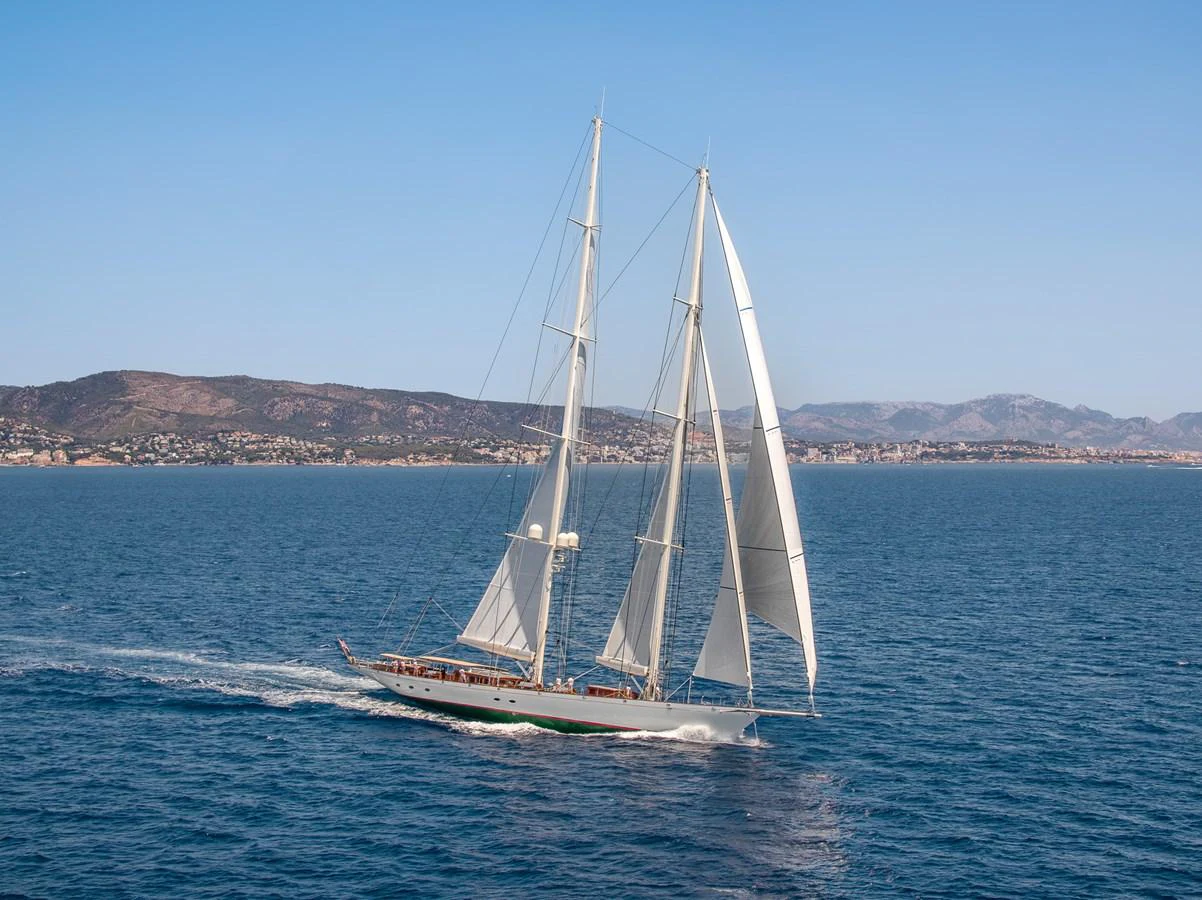 A stunning sailing yacht glides gracefully across the open sea with its sails fully unfurled. aboard ATHOS Yacht for Sale