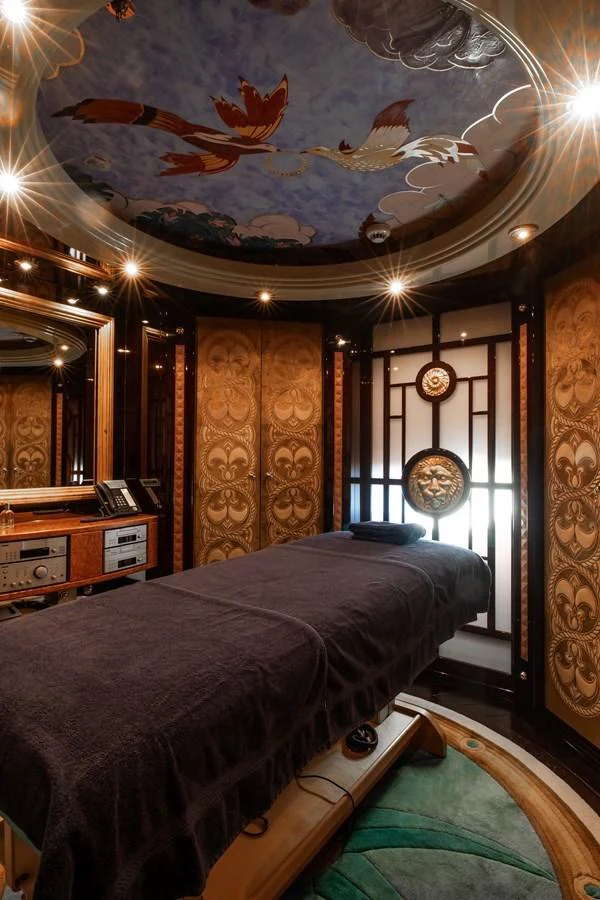 The yacht's spa room features an elegant massage table under an artistically painted ceiling. aboard LADY MARINA Yacht for Sale