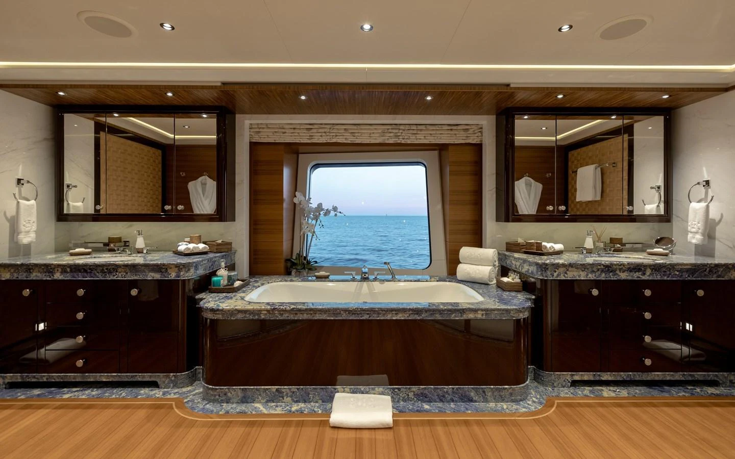 The yacht's bathroom features a luxurious double vanity and a central bathtub with a stunning ocean view. aboard BATON ROUGE Yacht for Sale