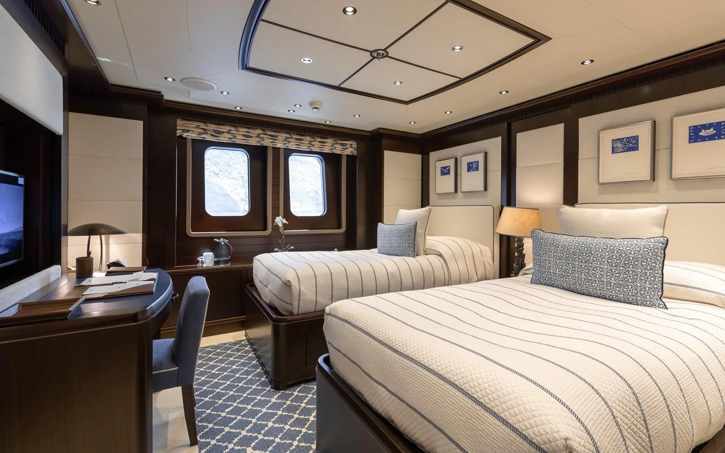 The guest stateroom features twin beds, a desk, and elegant decor with ample natural light. aboard BATON ROUGE Yacht for Sale