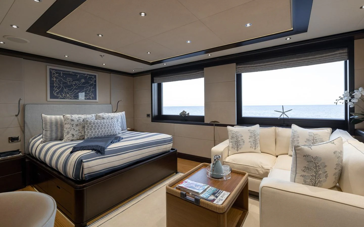 A luxurious stateroom featuring a comfortable bed and a cozy seating area with ocean views. aboard BATON ROUGE Yacht for Sale