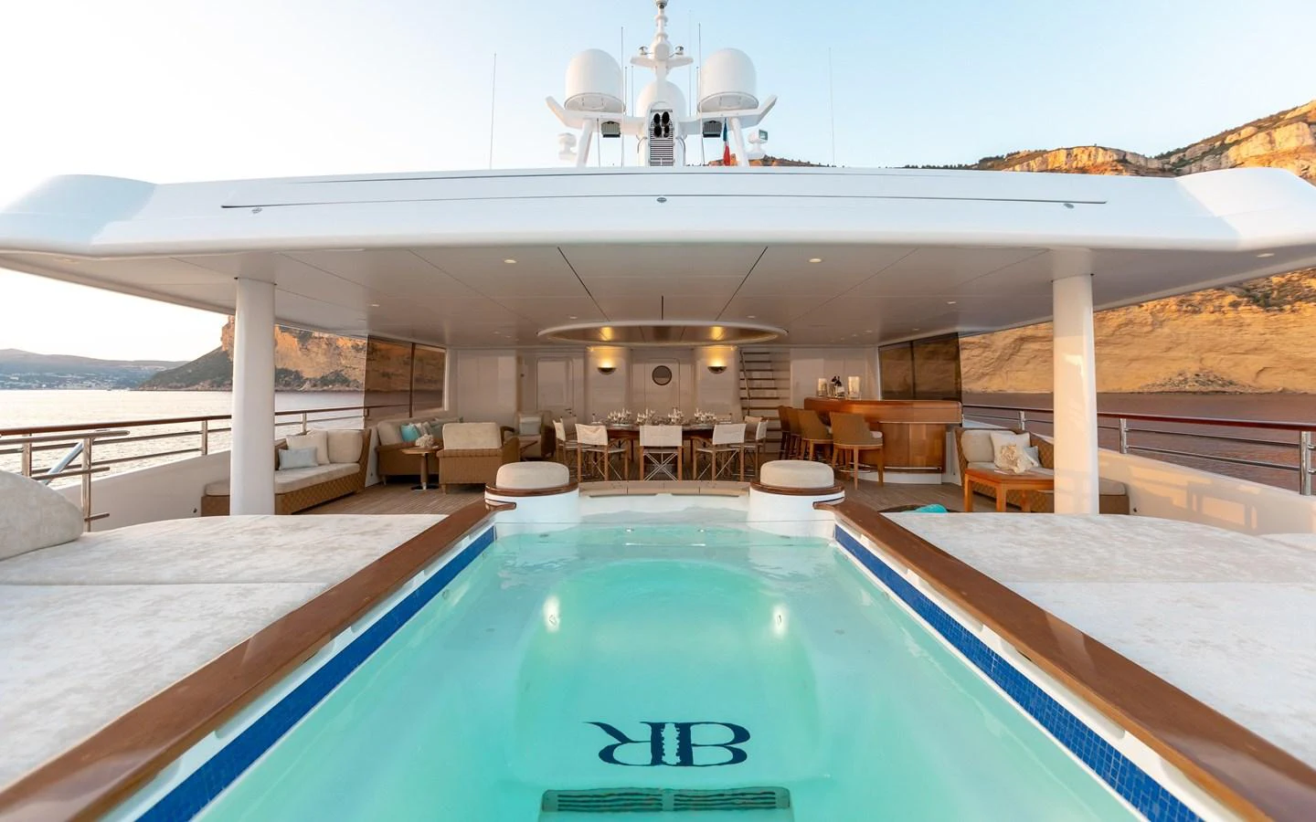 The aft deck features a luxurious pool with ample seating and dining areas, perfect for relaxation and entertainment. aboard BATON ROUGE Yacht for Sale
