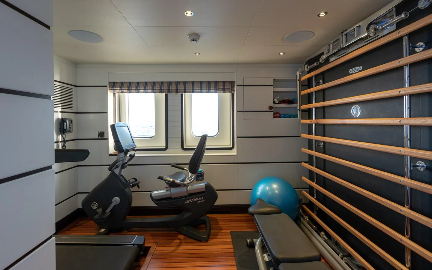 The yacht's gym is equipped with modern fitness equipment and offers a view through large windows. aboard BATON ROUGE Yacht for Sale