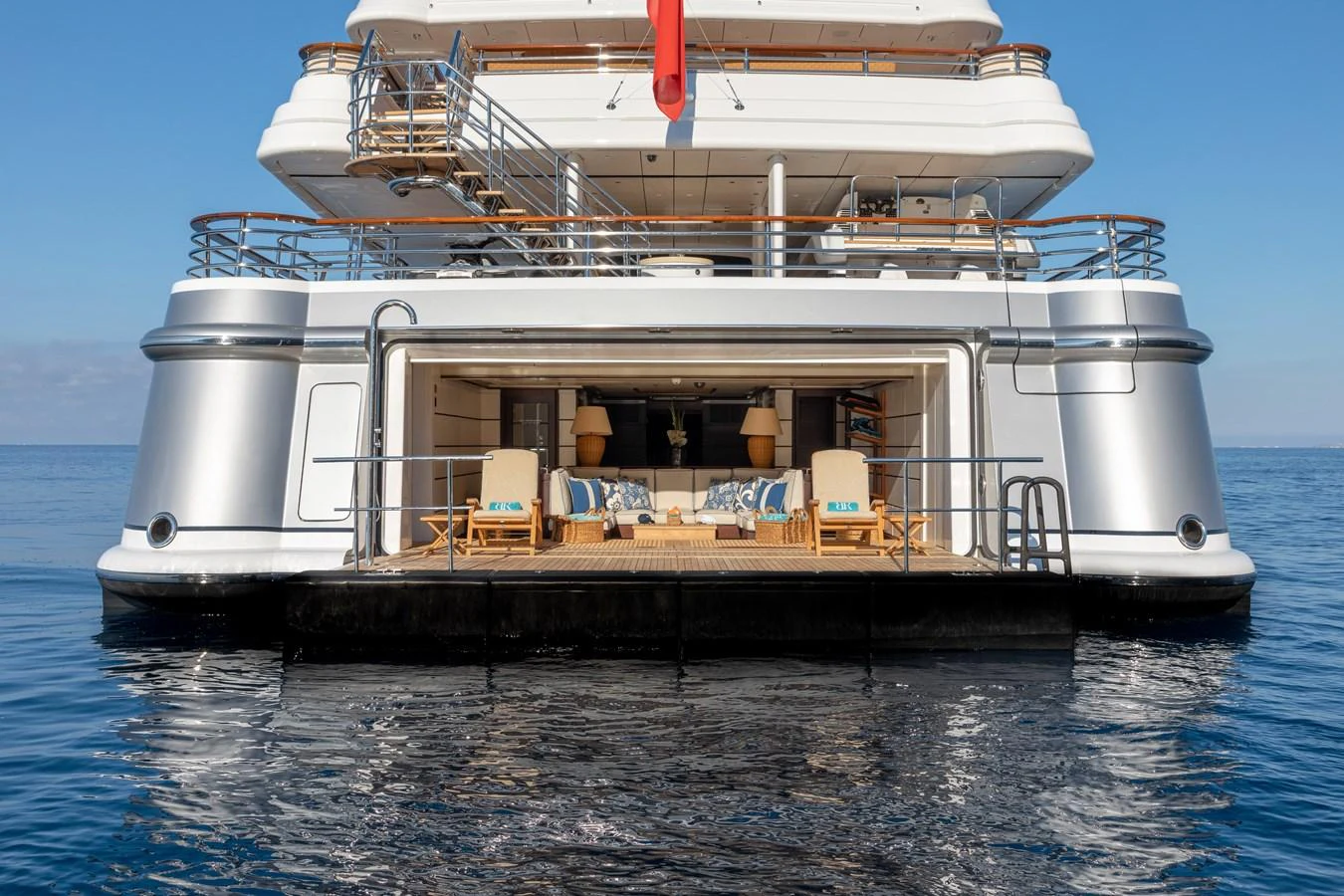 The yacht's aft deck opens to a luxurious lounging area with comfortable seating and elegant decor. aboard BATON ROUGE Yacht for Sale
