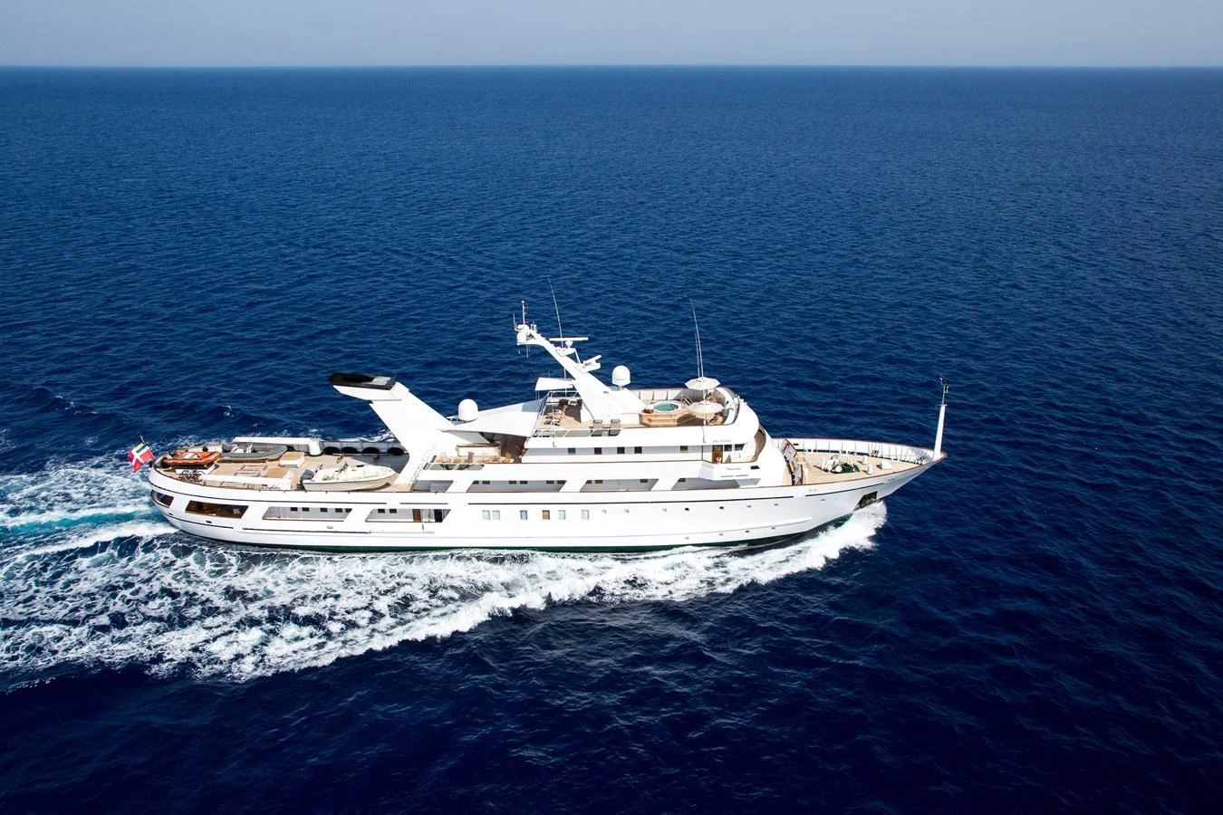 A luxurious yacht cruises through the open sea, showcasing its sleek design and spacious decks. aboard ESMERALDA Yacht for Sale