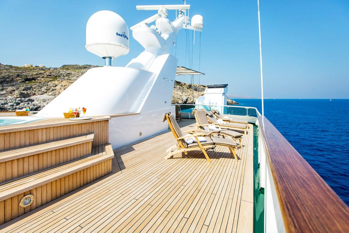 The sundeck offers a luxurious space for relaxation with sun loungers and a stunning sea view. aboard ESMERALDA Yacht for Sale