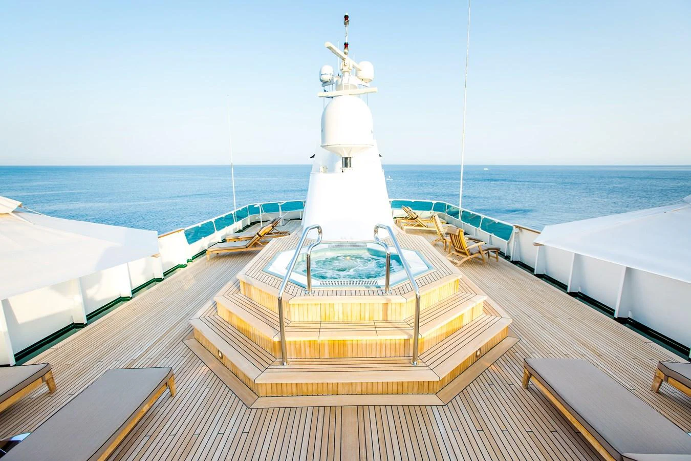 The sundeck features a luxurious jacuzzi surrounded by sun loungers, offering panoramic ocean views. aboard ESMERALDA Yacht for Sale