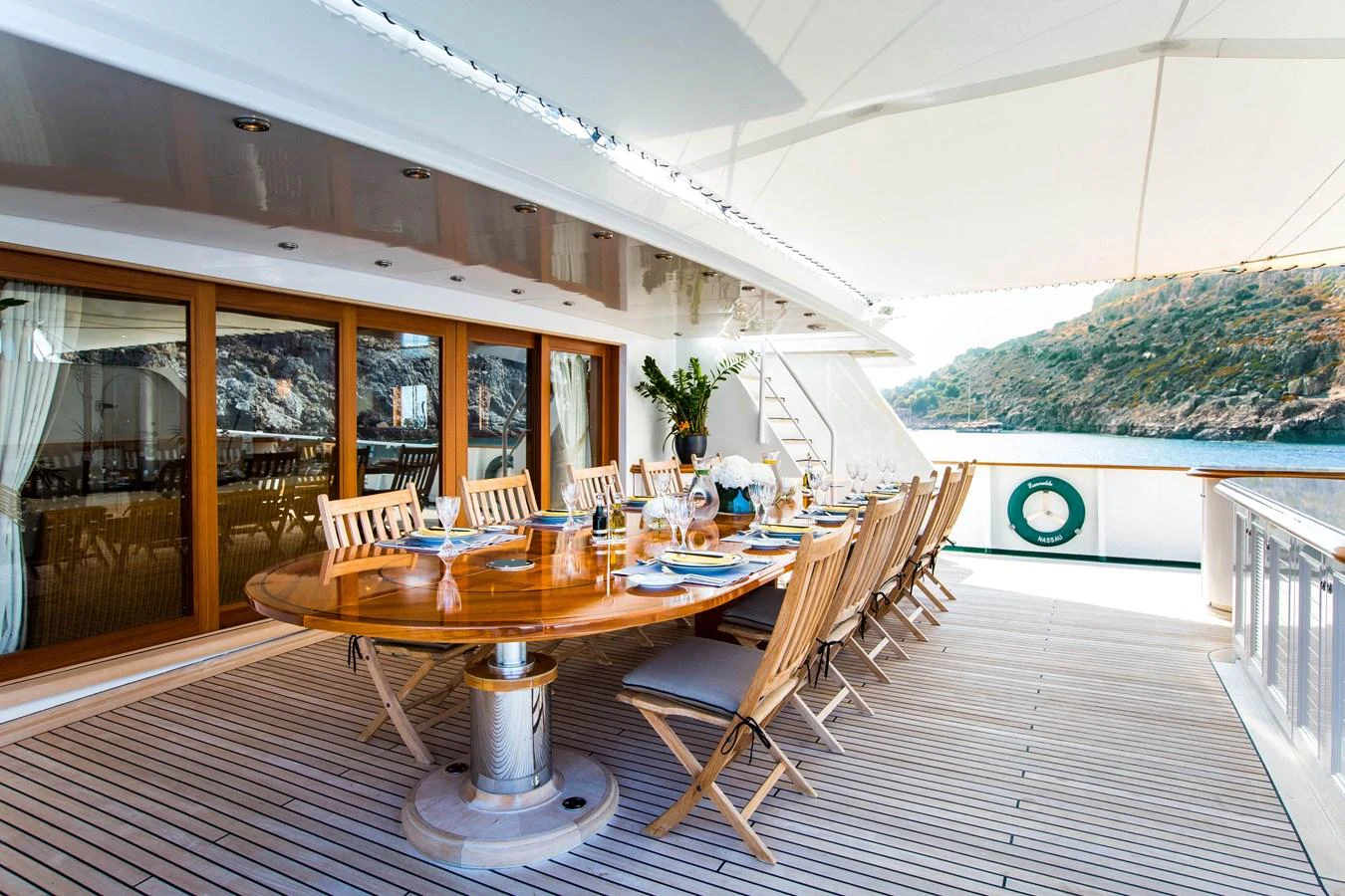 The aft deck features an elegant dining area with a large wooden table and comfortable chairs, perfect for alfresco dining. aboard ESMERALDA Yacht for Sale