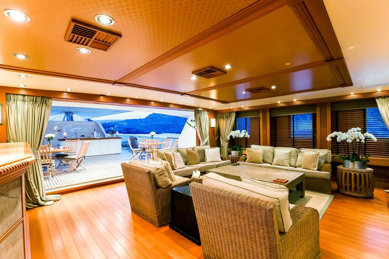 The yacht's salon features a spacious seating area with elegant furnishings and a view of the aft deck. aboard ESMERALDA Yacht for Sale