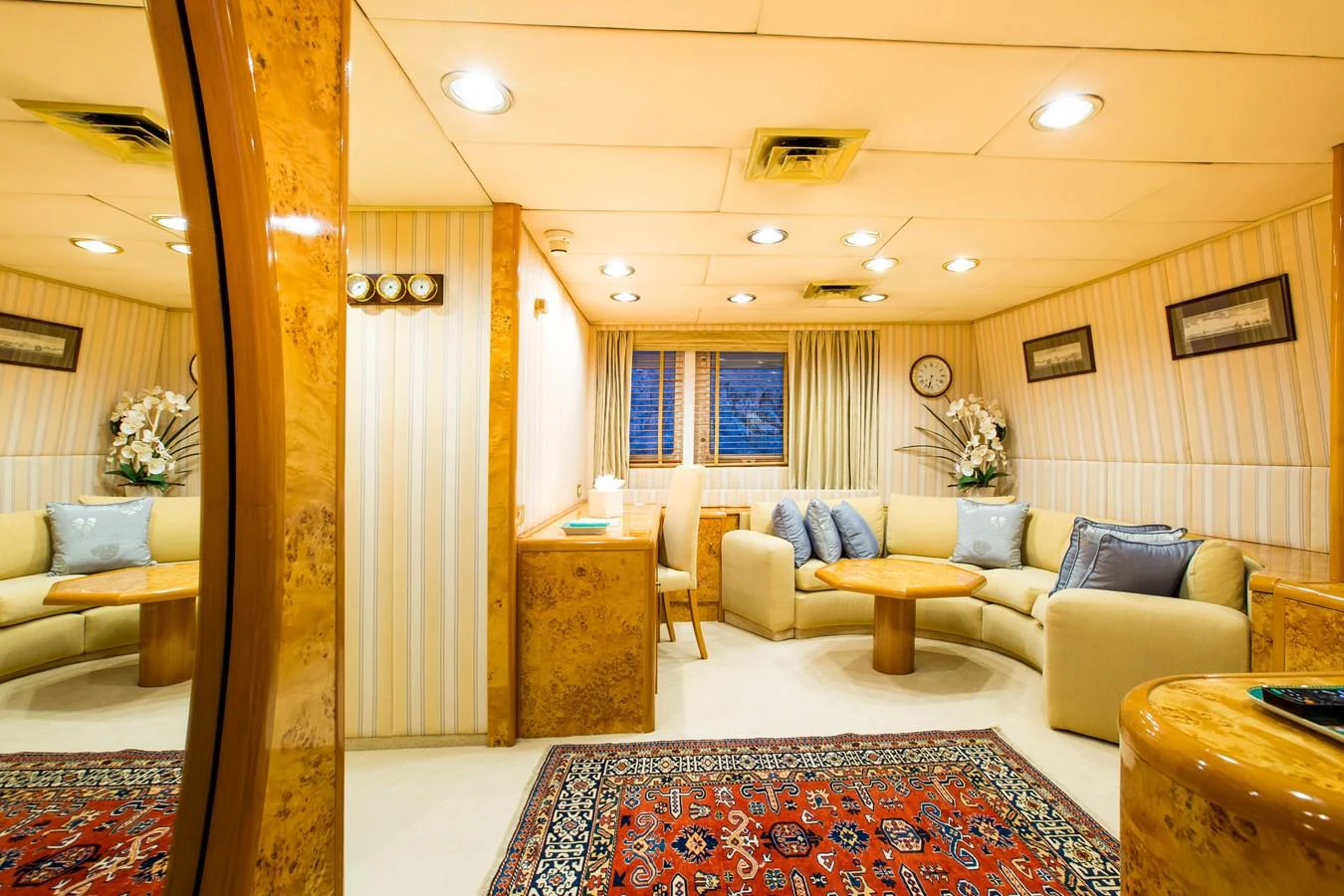 The yacht's interior features a cozy and well-lit lounge area with comfortable seating and elegant decor. aboard ESMERALDA Yacht for Sale