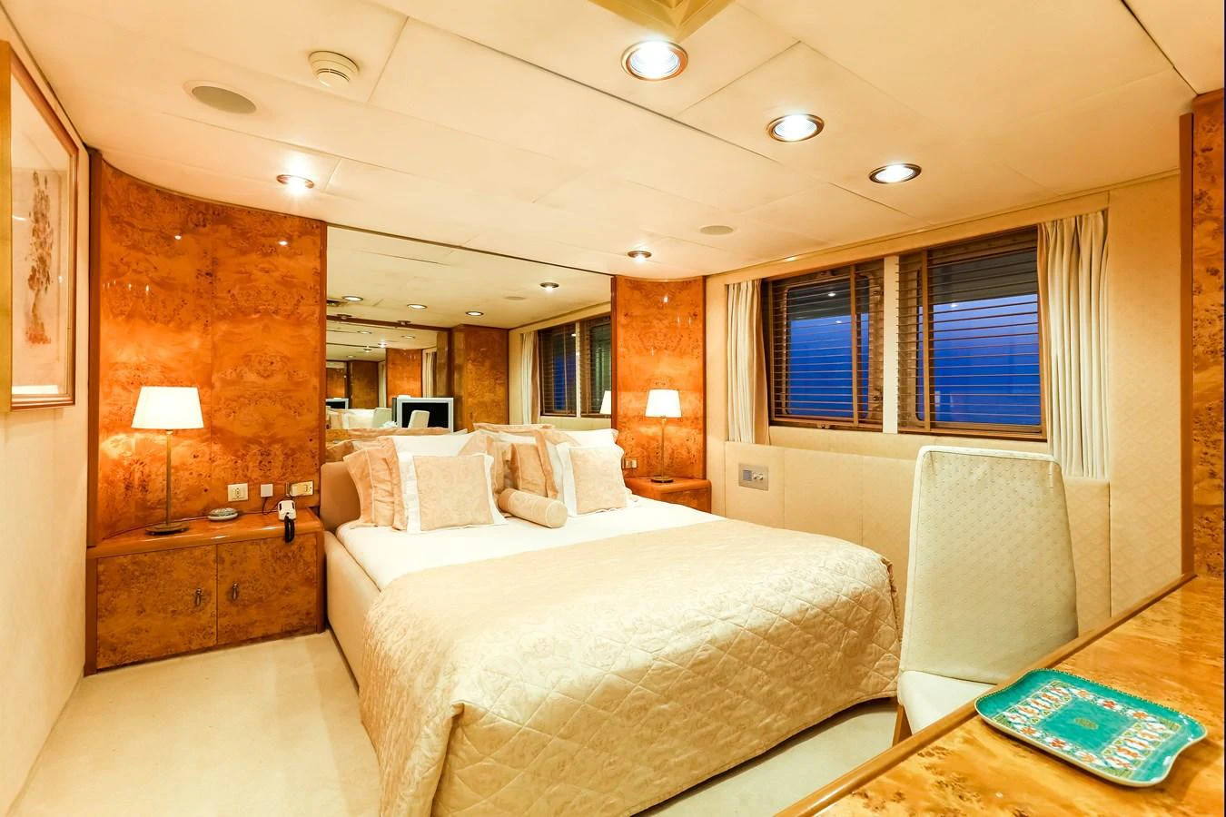 The master stateroom features a luxurious bed with elegant lighting and wood paneling. aboard ESMERALDA Yacht for Sale