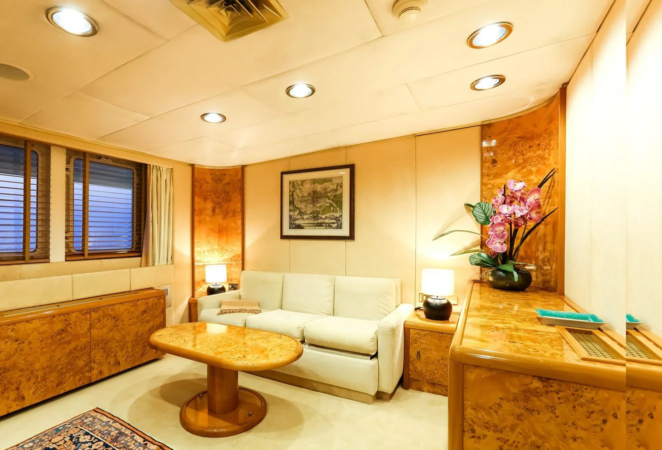 The salon features a cozy seating area with elegant wood finishes and soft lighting. aboard ESMERALDA Yacht for Sale