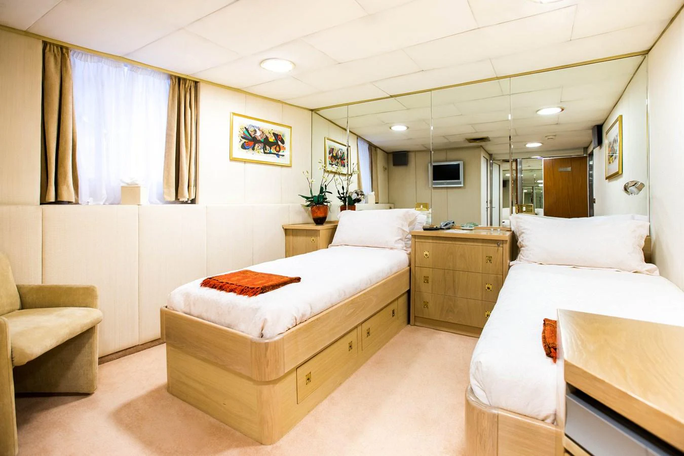 A cozy twin stateroom with comfortable beds and warm lighting. aboard ESMERALDA Yacht for Sale