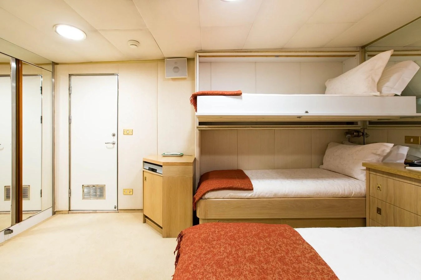 The guest cabin features cozy bunk beds with warm-toned bedding and ample storage space. aboard ESMERALDA Yacht for Sale