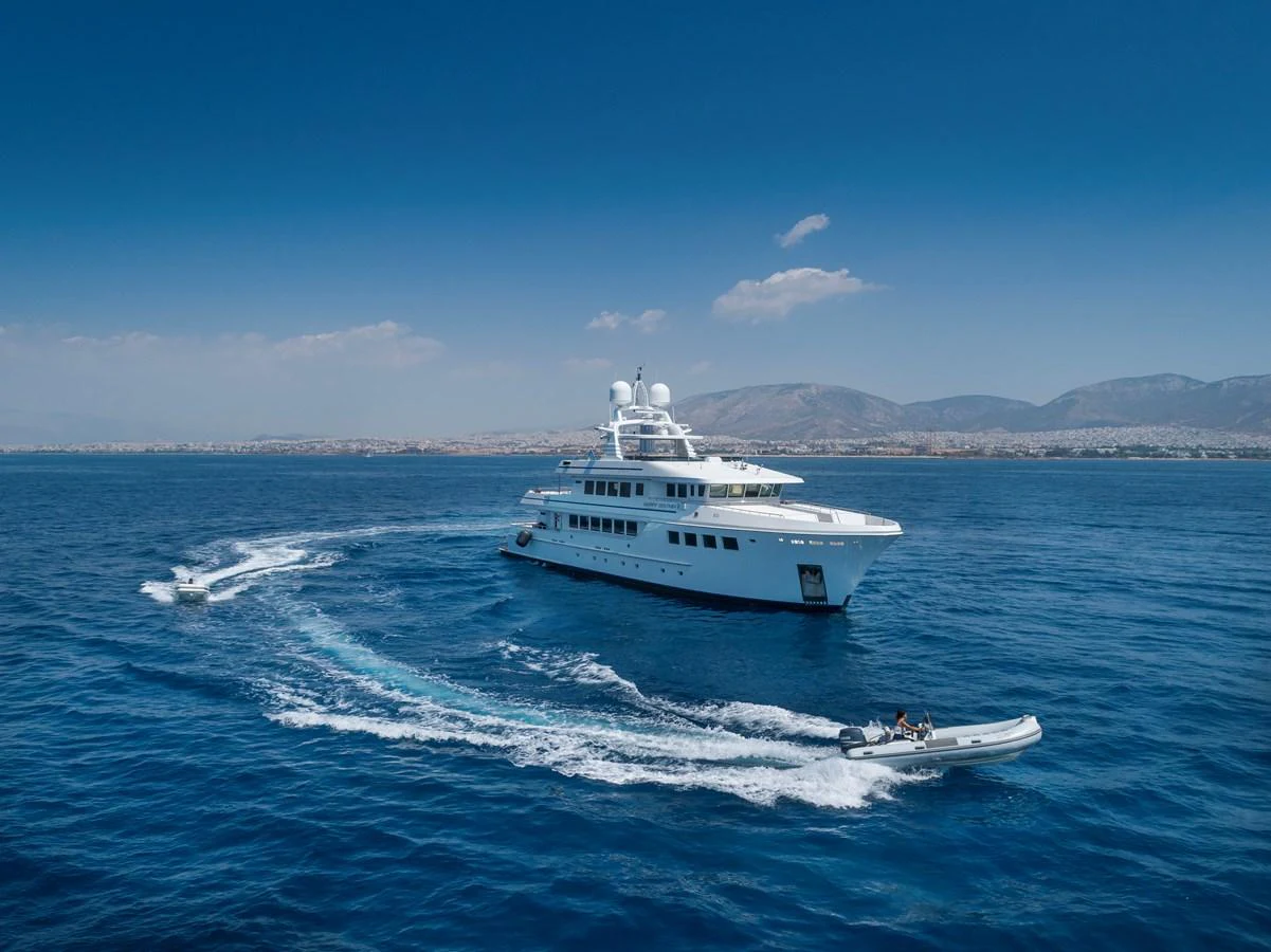 A luxurious yacht sails gracefully on the open sea, accompanied by a tender boat. aboard HAPPY DOLPHIN II Yacht for Sale