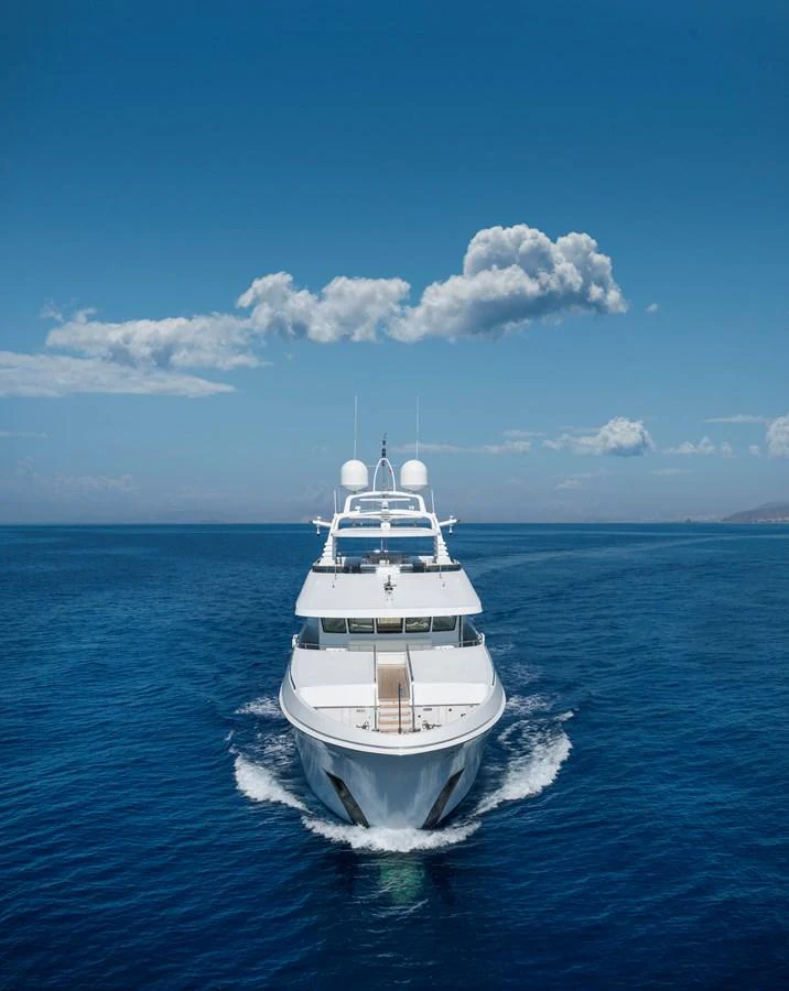 A luxurious yacht sails forward on a calm, clear blue sea under a bright sky. aboard HAPPY DOLPHIN II Yacht for Sale