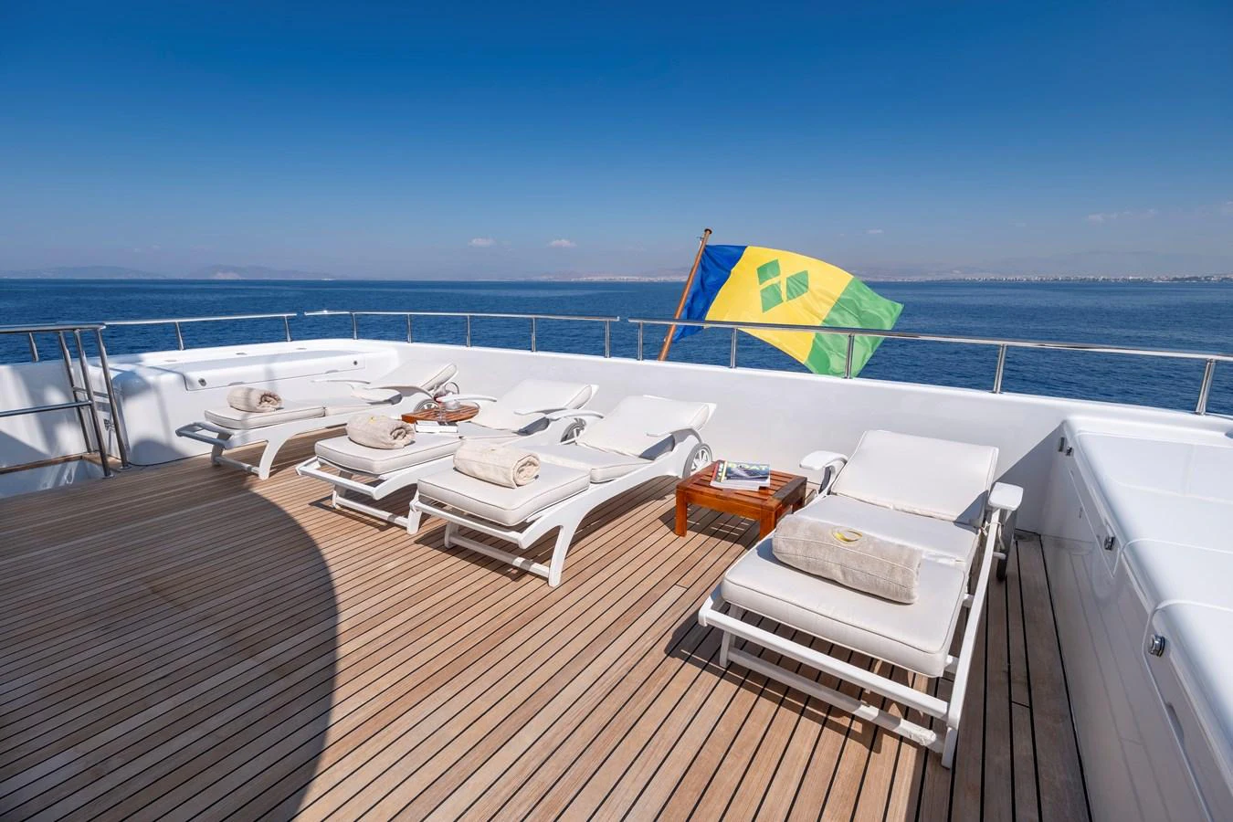 The sundeck offers a serene space with sun loungers and a beautiful ocean view. aboard HAPPY DOLPHIN II Yacht for Sale