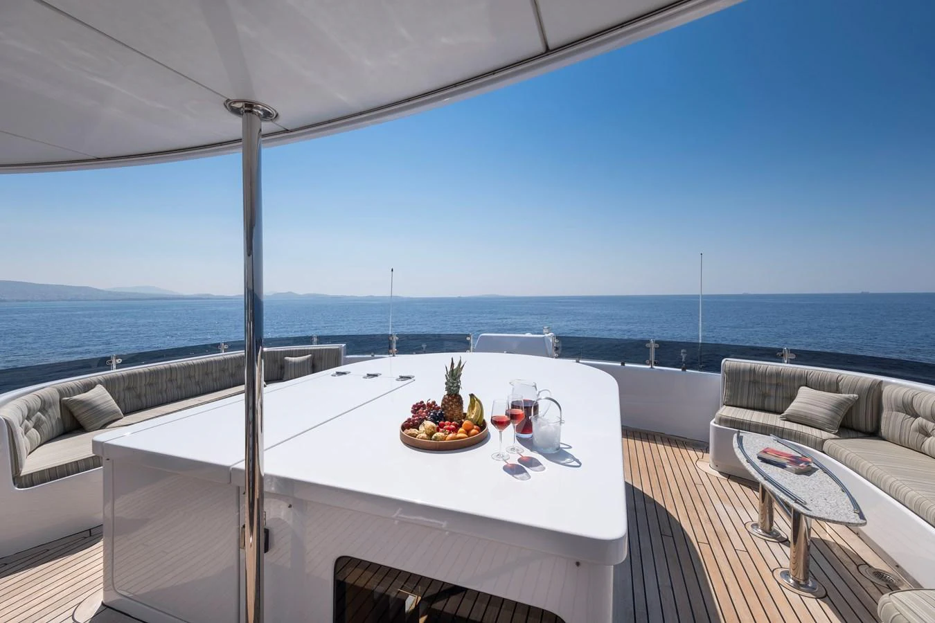 The aft deck features a spacious dining area with stunning ocean views. aboard HAPPY DOLPHIN II Yacht for Sale