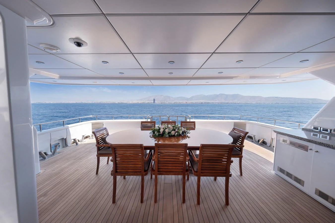 The aft deck features an elegant dining area with a stunning ocean view. aboard HAPPY DOLPHIN II Yacht for Sale