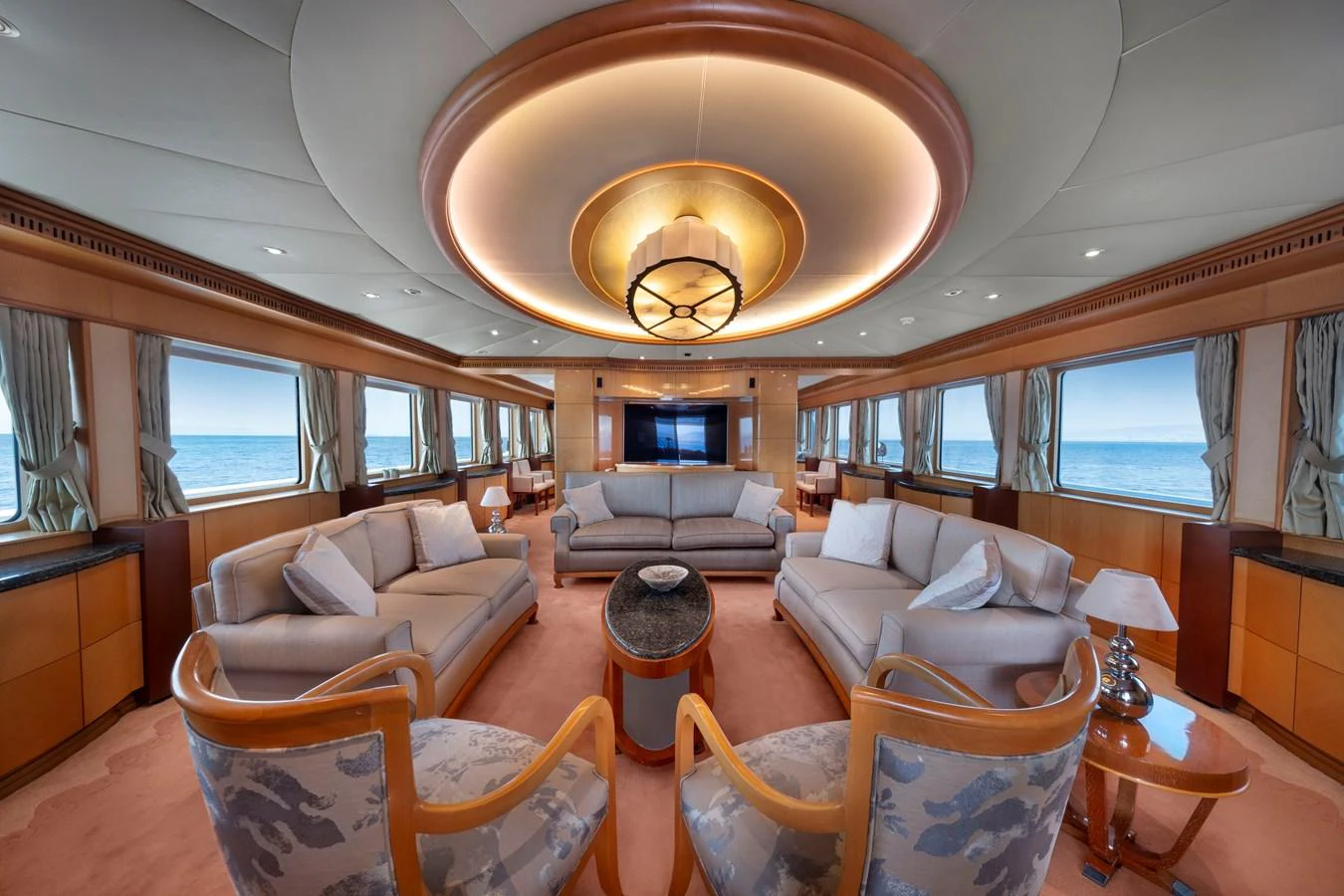 The salon offers a spacious and luxurious seating area with panoramic ocean views. aboard HAPPY DOLPHIN II Yacht for Sale