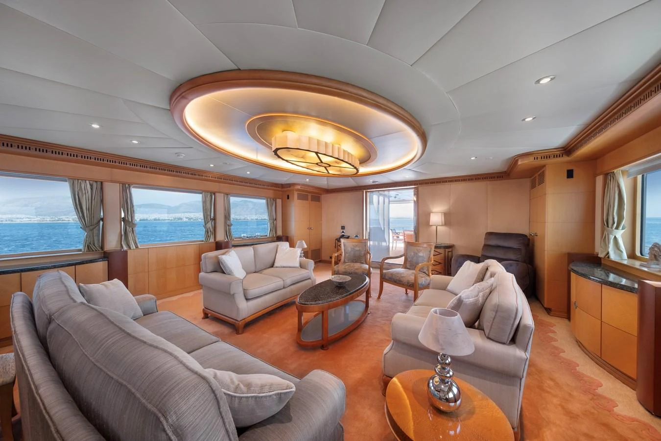 The yacht's salon features luxurious seating with panoramic ocean views. aboard HAPPY DOLPHIN II Yacht for Sale