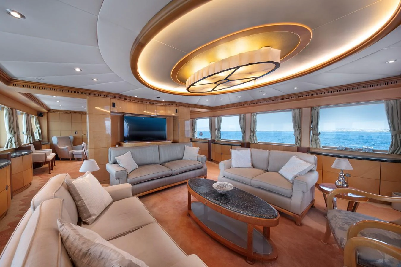 The salon offers a spacious and luxurious seating area with panoramic ocean views. aboard HAPPY DOLPHIN II Yacht for Sale
