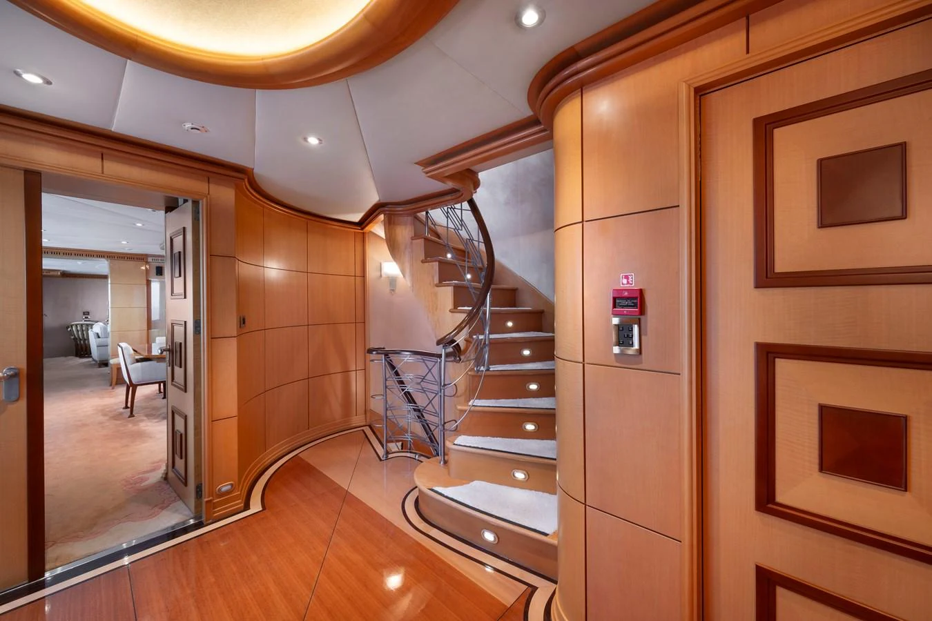 The yacht's interior features a beautifully crafted staircase with elegant wood paneling and modern lighting. aboard HAPPY DOLPHIN II Yacht for Sale