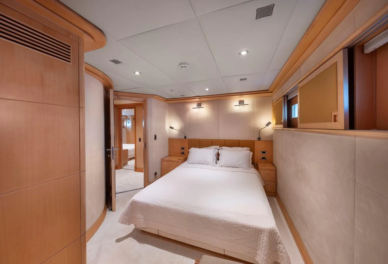 A cozy stateroom featuring a comfortable bed and warm wood accents. aboard HAPPY DOLPHIN II Yacht for Sale