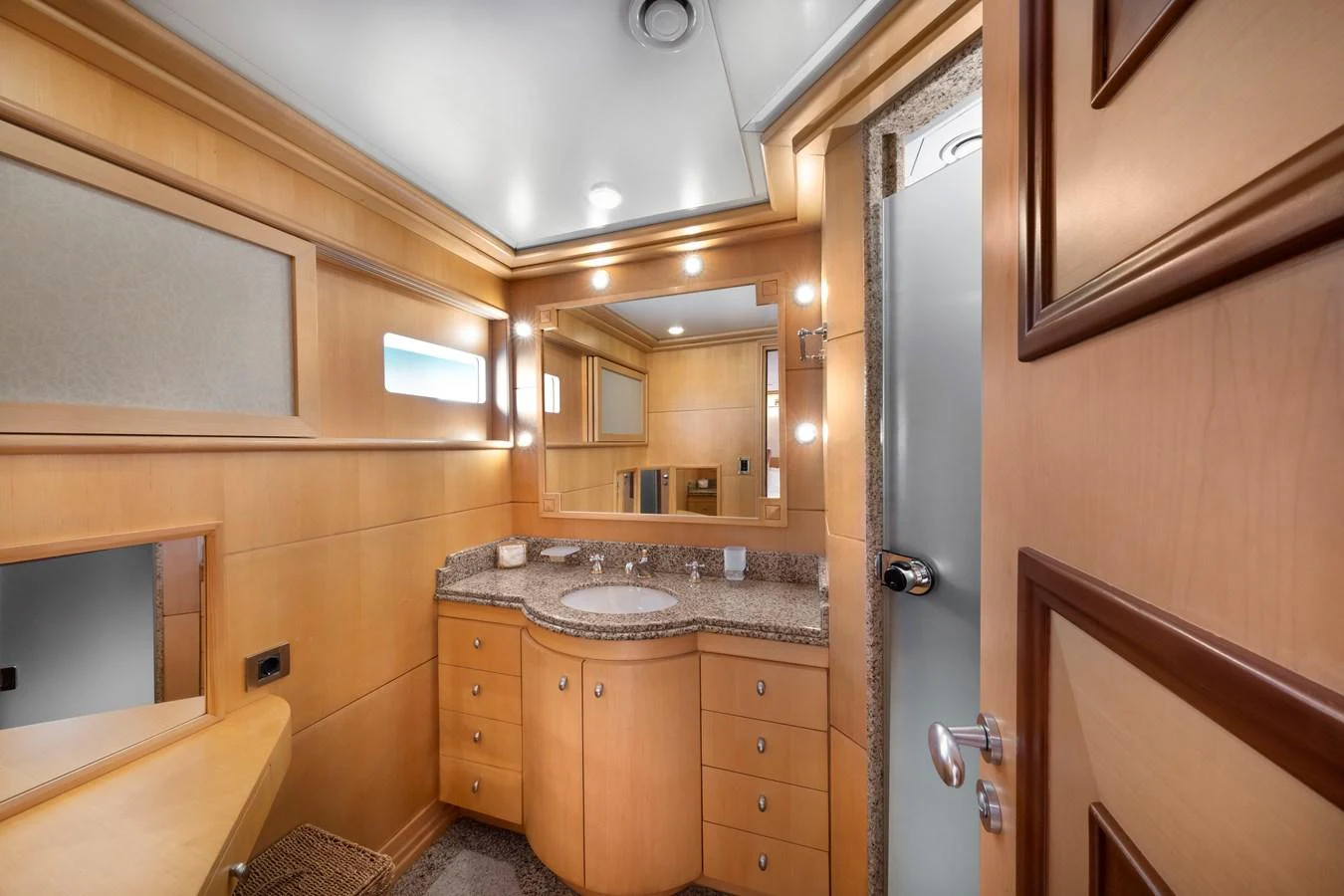 The yacht's bathroom features elegant wood paneling and a spacious vanity area. aboard HAPPY DOLPHIN II Yacht for Sale