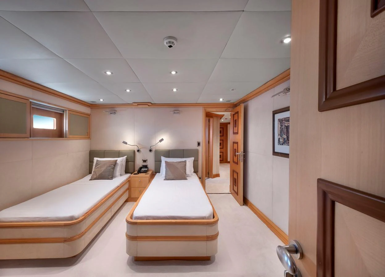 The twin stateroom offers a cozy and elegant sleeping area with two single beds and tasteful decor. aboard HAPPY DOLPHIN II Yacht for Sale